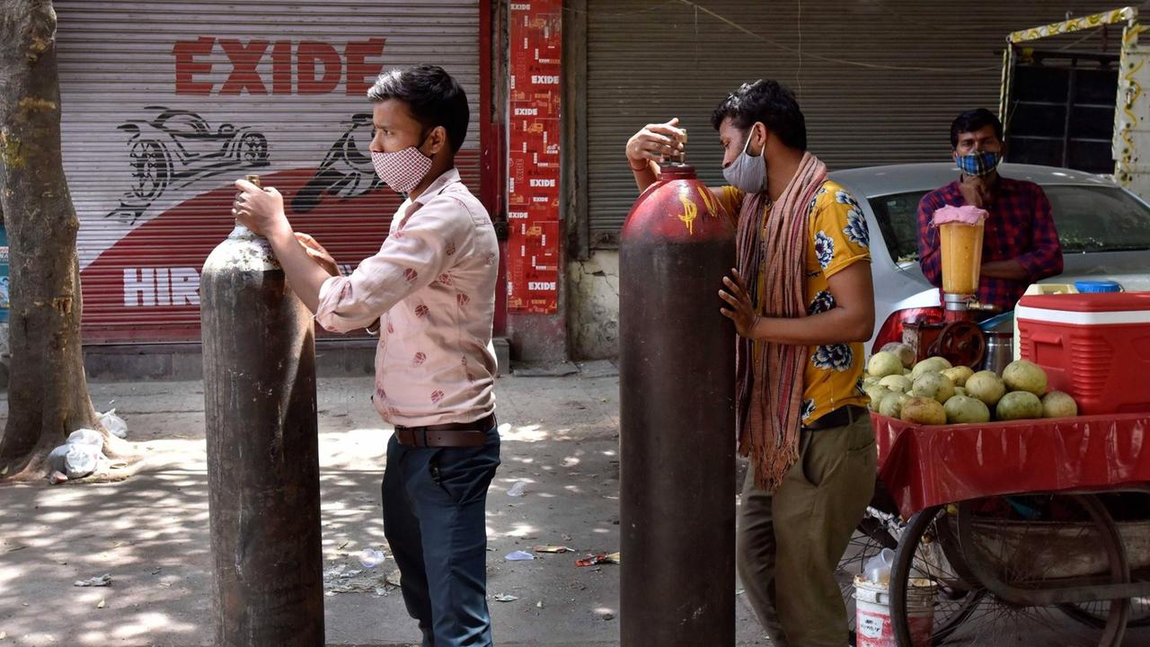 Zwei Männer gestützt auf Sauerstofflaschen warten in einer Schlange vor einem Geschäft eines Sauerstofflieferanten am 4. Mai 2021 in Neu-Delhi. Zwei Männer gestützt auf Sauerstofflaschen warten in einer Schlange vor einem Geschäft eines Sauerstofflieferanten am 4. Mai 2021 in Neu-Delhi.