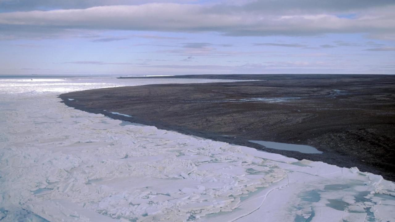 Blick auf die zu Russland gehörende Bolschewik-Insel. Im Vordergrund Packeis, im Hintergrund ist die Landschaft schon aufgetaut und schlammig. Blick auf die zu Russland gehörende Bolschewik-Insel. Im Vordergrund Packeis, im Hintergrund ist die Landschaft schon aufgetaut und schlammig.
