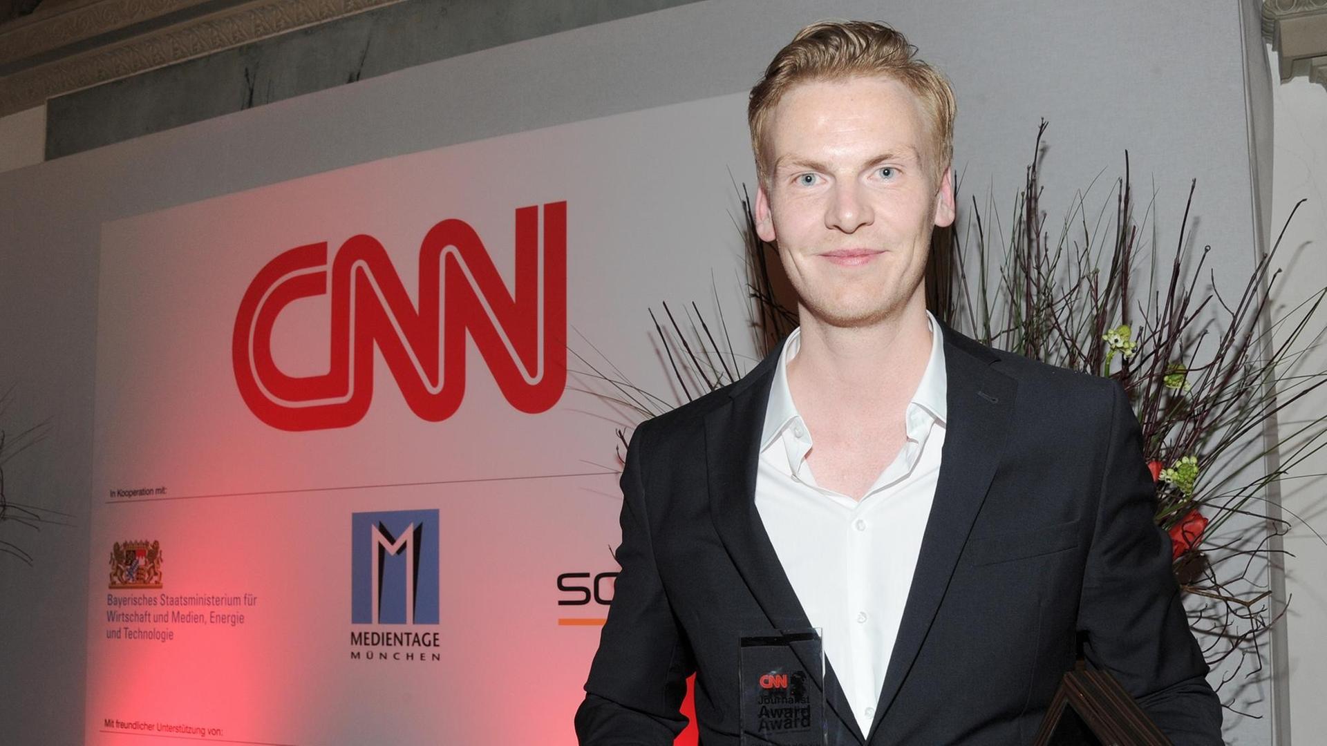 Der Journalist Claas Relotius präsentiert 2014 auf einer Gala in München seine Auszeichnung zum "CNN Journalist Of The Year".