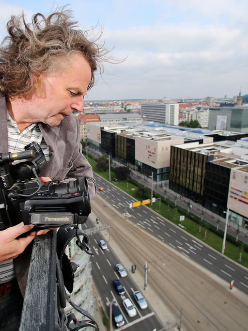 Der Journalist Siegbert Schefke steht mit seiner alten Videokamera auf dem Turm der Reformierten Kirche in Leipzig. Schefke filmte am 9. Oktober 1989 mit seinem Kollegen Aram Radomski eine Montagsdemo vom Turm der Kirche aus.