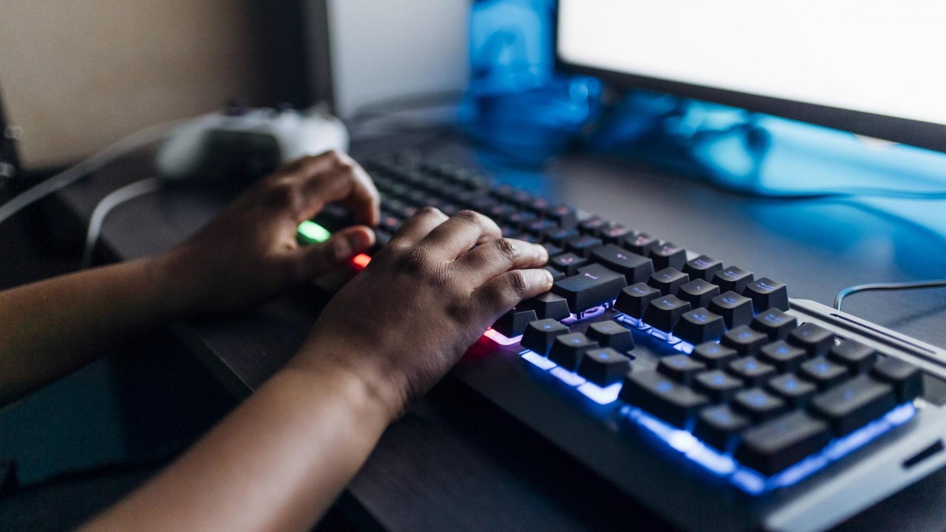 Kinderhände auf einer leuchtenden Spiele-Tastatur Kinderhände auf einer leuchtenden Spiele-Tastatur