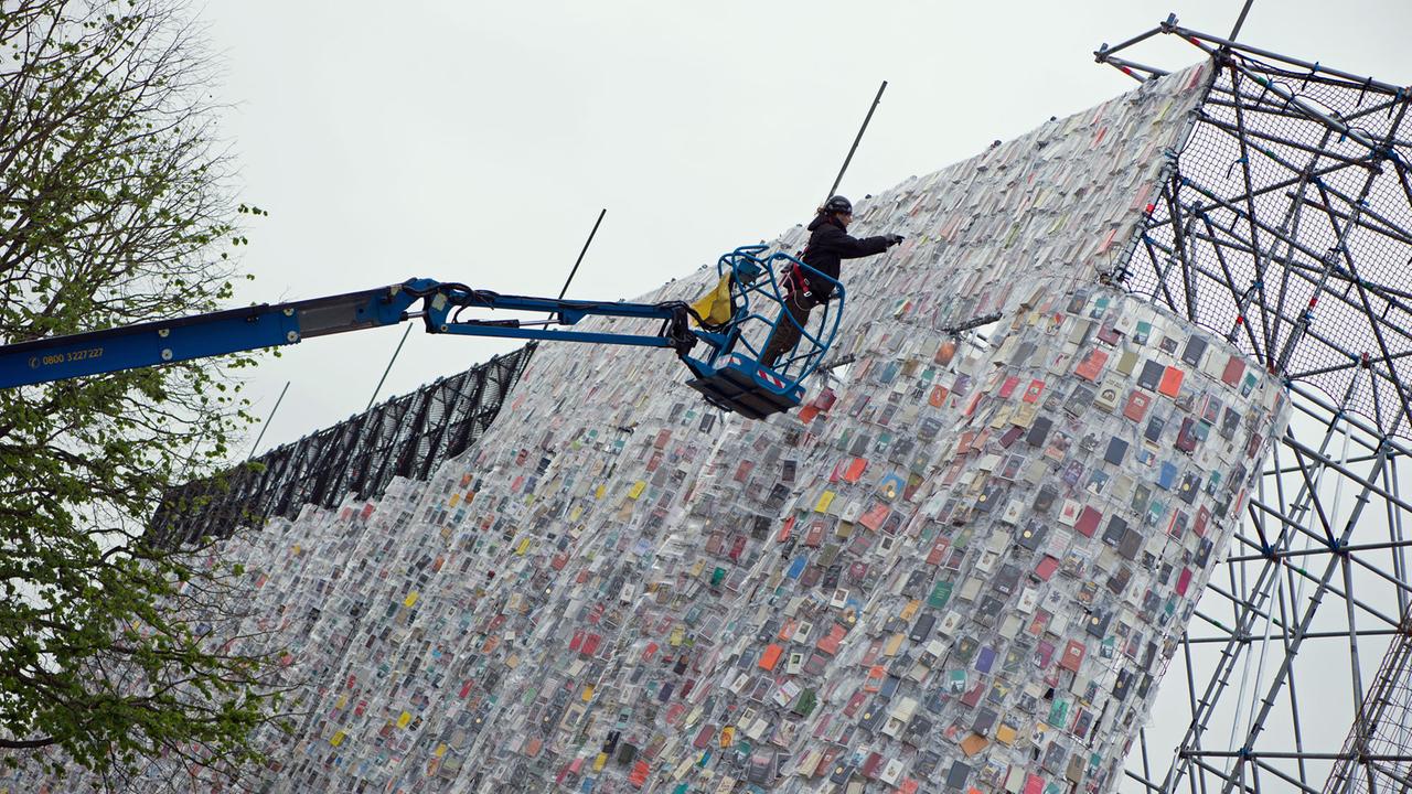 Ein Arbeiter hängt am 04.05.2017 in Plastik eingehüllte Bücher an das Stahlgerüst des documenta-Kunstwerks "The Parthenon of Books" in Kassel. Der Nachbau des Parthenon-Tempels der argentinischen Künstlerin Marta Minujin gehört zu den größten Projekten der Documenta. Die documenta 14 in Kassel findet vom 10.06.2017 bis zum 17.09.2017 statt. Ein Arbeiter hängt am 04.05.2017 in Plastik eingehüllte Bücher an das Stahlgerüst des documenta-Kunstwerks "The Parthenon of Books" in Kassel. Der Nachbau des Parthenon-Tempels der argentinischen Künstlerin Marta Minujin gehört zu den größten Projekten der Documenta. Die documenta 14 in Kassel findet vom 10.06.2017 bis zum 17.09.2017 statt.