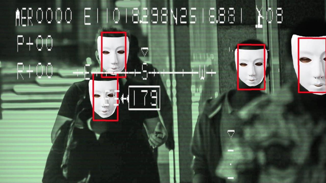 Bild eines Überwachungsmonitors mit Gesichtserkennung: Im Kamerabild sind Menschen mit Masken zu sehen. Bild eines Überwachungsmonitors mit Gesichtserkennung: Im Kamerabild sind Menschen mit Masken zu sehen.