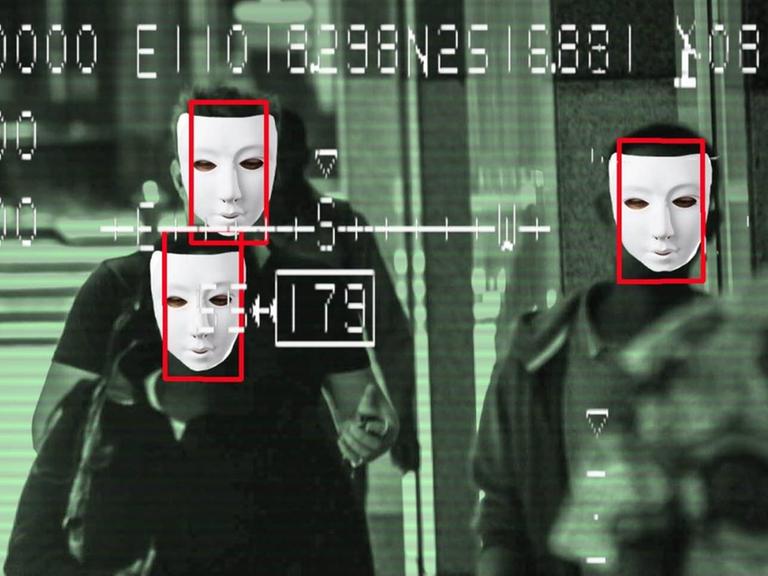 Bild eines Überwachungsmonitors mit Gesichtserkennung: Im Kamerabild sind Menschen mit Masken zu sehen.