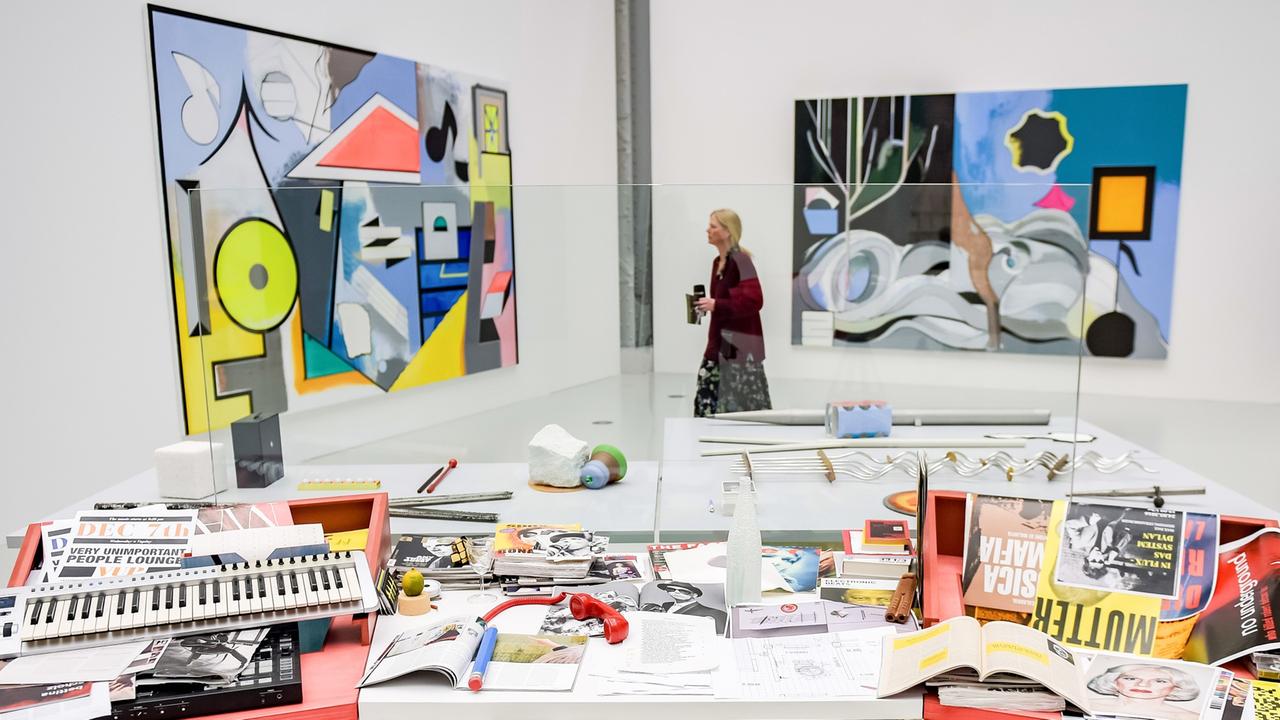 Eine Frau betrachtet in der Ausstellung "Hyper! A Journey into Art and Music" in den Deichtorhallen Bilder des Malers und Bildhauers Thomas Scheibitz die hinter der Installation "Regieraum/Masterplan Tisch" desselben Künstlers hängen. Eine Frau betrachtet in der Ausstellung "Hyper! A Journey into Art and Music" in den Deichtorhallen Bilder des Malers und Bildhauers Thomas Scheibitz die hinter der Installation "Regieraum/Masterplan Tisch" desselben Künstlers hängen.
