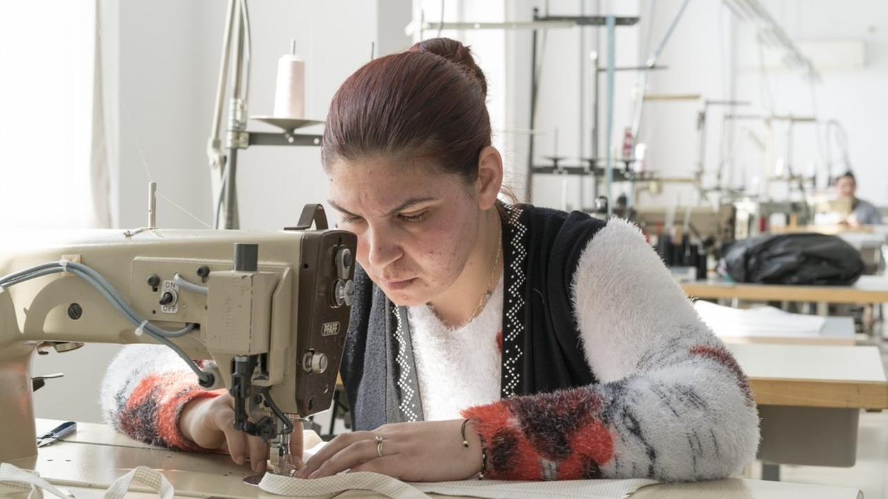 In der "Zukunftsnäherei" werden seit 2015 Frauen aus der Roma-Siedlung Stolipinowo ausgebildet. Die Finanzierung ist ungewiss. EU-Gelder sind befristet. Eine Näherin sitzt vor der Maschine.