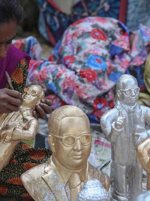 Eine indische Dalit-Frau stellt Ambedkar-Statuen in Mumbai aus.