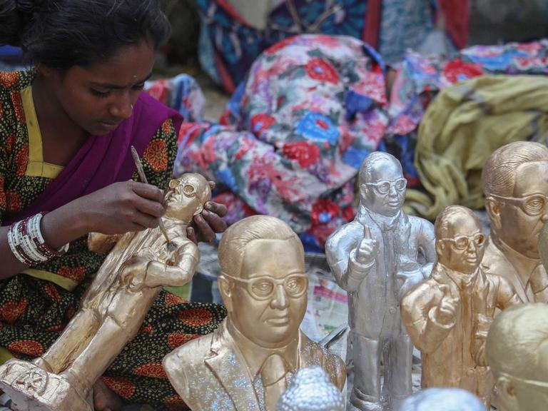 Eine indische Dalit-Frau stellt Ambedkar-Statuen in Mumbai aus.