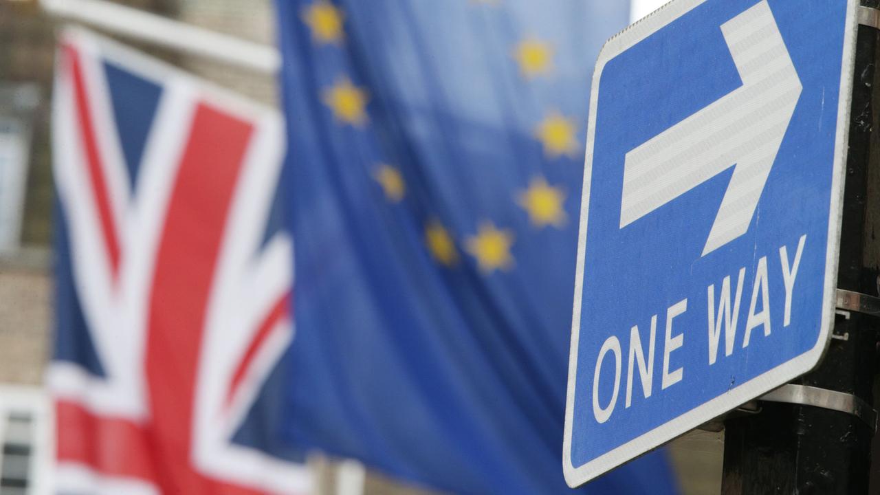 Weg von der EU ist jetzt der einzige englische Weg: Einbahnstraßenschild steht am 10.3.2017 am Europahaus am Smith Square in London vor einer Europaflagge und einem Union Jack dahinter. Weg von der EU ist jetzt der einzige englische Weg: Einbahnstraßenschild steht am 10.3.2017 am Europahaus am Smith Square in London vor einer Europaflagge und einem Union Jack dahinter.