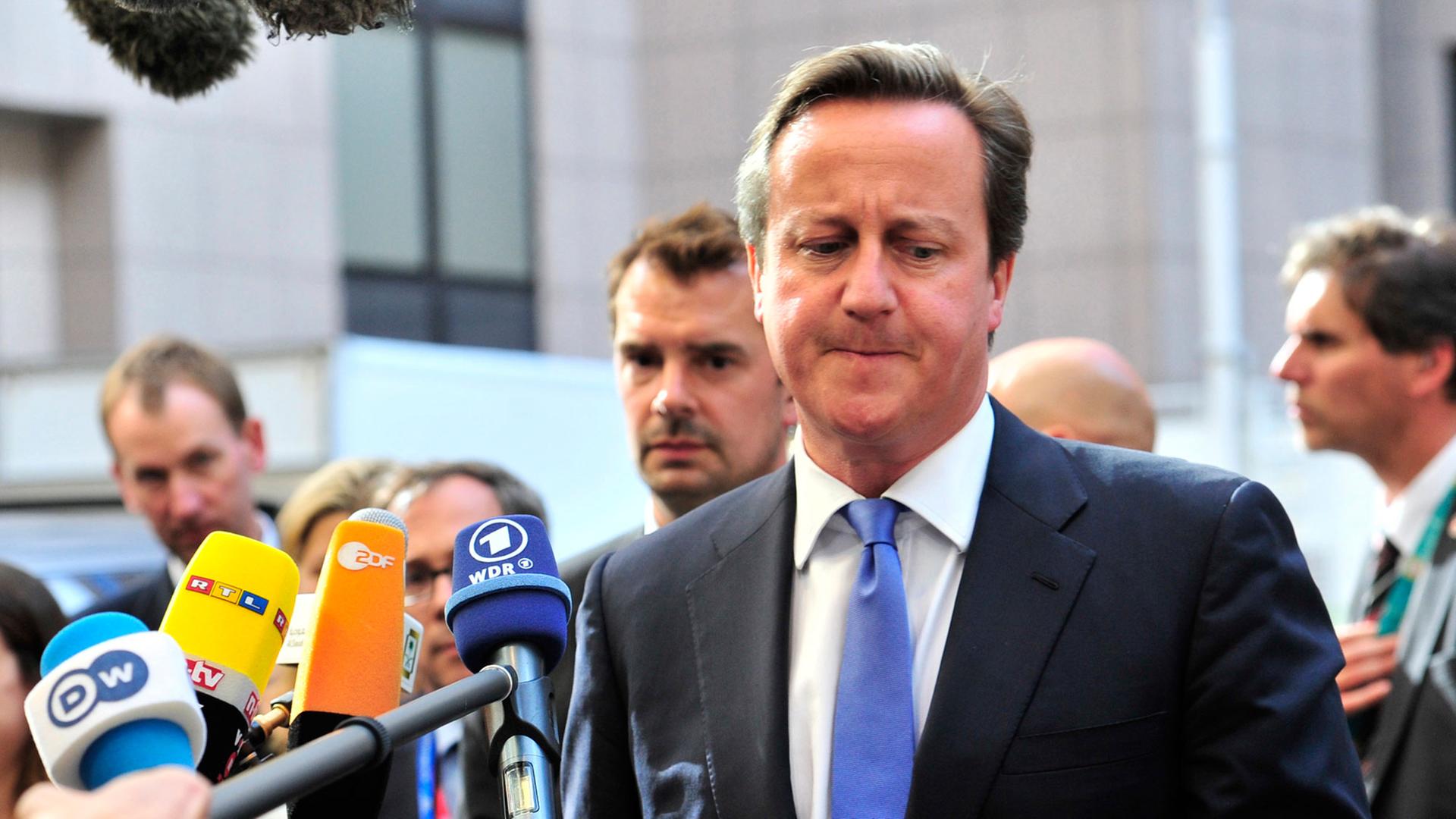 Der britische Premierminister David Cameron beim Gang in die Zentrale der Europäischen in Union in Brüssel, Pressevertreter halten ihm Mikrofone hin. Der britische Premierminister David Cameron beim Gang in die Zentrale der Europäischen in Union in Brüssel, Pressevertreter halten ihm Mikrofone hin.