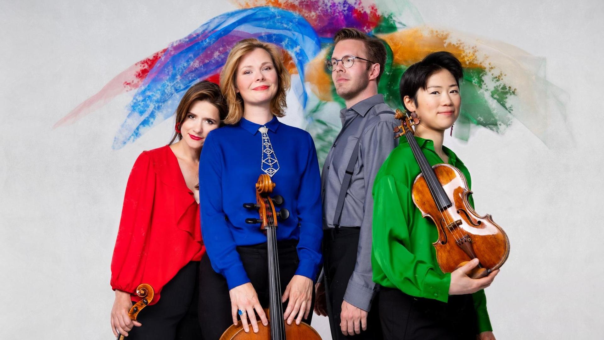 Die vier Ensemblemitglieder in farbiger Konzertkleidung vor einer Blau-Orange-Grün-Roten Wand Die vier Ensemblemitglieder in farbiger Konzertkleidung vor einer Blau-Orange-Grün-Roten Wand