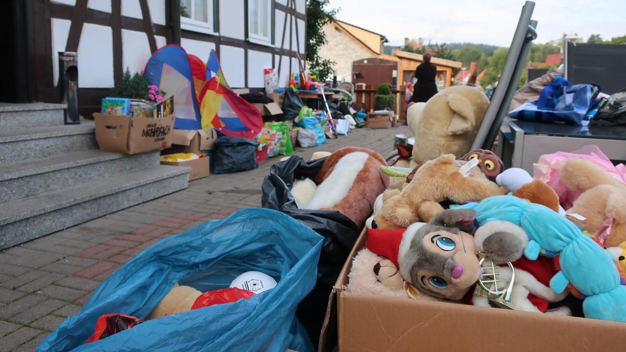 Auf einem Bürgersteig stehen Pappkisten gefüllt mit Stofftieren Auf einem Bürgersteig stehen Pappkisten gefüllt mit Stofftieren
