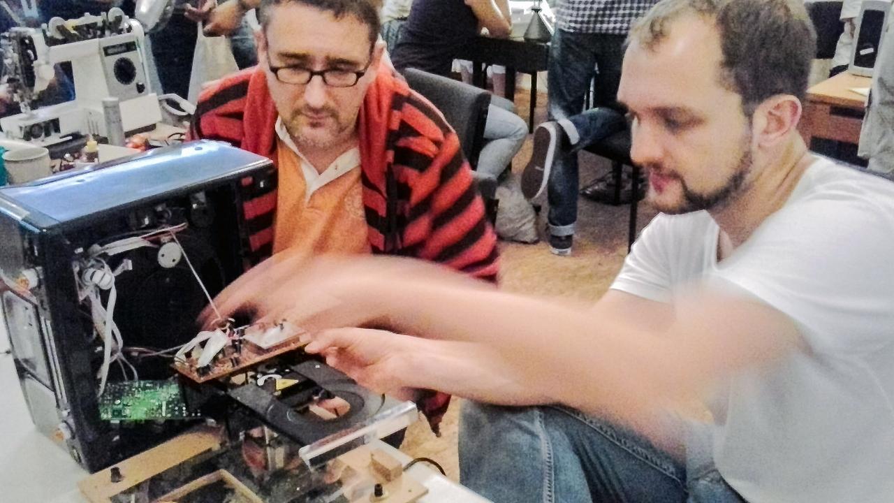 Zu sehen sind Studenten, die an Elektrogeräten herumbasteln, um sie wieder in Gang zu bringen. Zu sehen sind Studenten, die an Elektrogeräten herumbasteln, um sie wieder in Gang zu bringen.