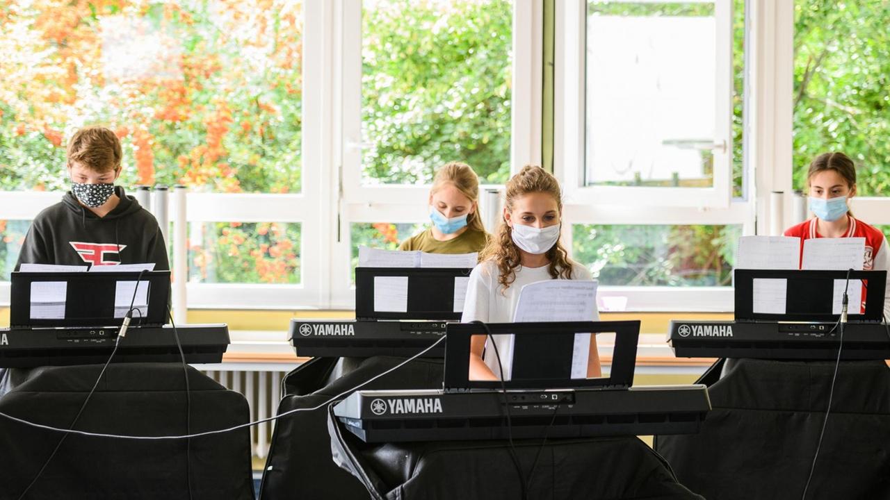 17.08.2020, Rheinland-Pfalz, Mainz: Schülerinnen und Schüler zeigen einen Corona-konformen Musikunterricht. Die Ministerpräsidentin und die Bildungsministerin von Rheinland-Pfalz (beide SPD) besuchen zum Schulstart die Lenneberg Grund- und Realschule plus im Stadtteil Budenheim. Foto: Andreas Arnold/dpa | Verwendung weltweit 17.08.2020, Rheinland-Pfalz, Mainz: Schülerinnen und Schüler zeigen einen Corona-konformen Musikunterricht. Die Ministerpräsidentin und die Bildungsministerin von Rheinland-Pfalz (beide SPD) besuchen zum Schulstart die Lenneberg Grund- und Realschule plus im Stadtteil Budenheim. Foto: Andreas Arnold/dpa | Verwendung weltweit