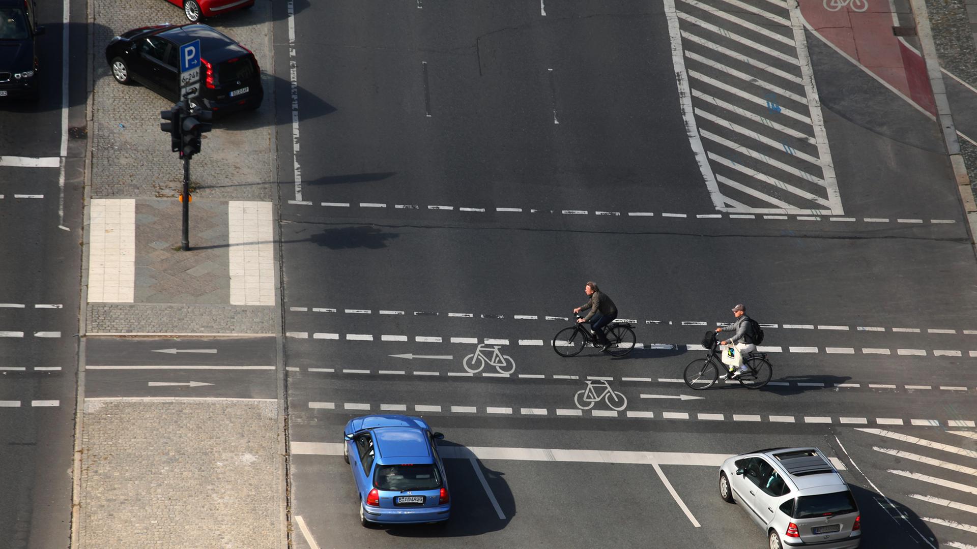 Zwei Radfahrer überqueren eine Kreuzung an einer Hauptstraße in Berlin. Zwei Radfahrer überqueren eine Kreuzung an einer Hauptstraße in Berlin.
