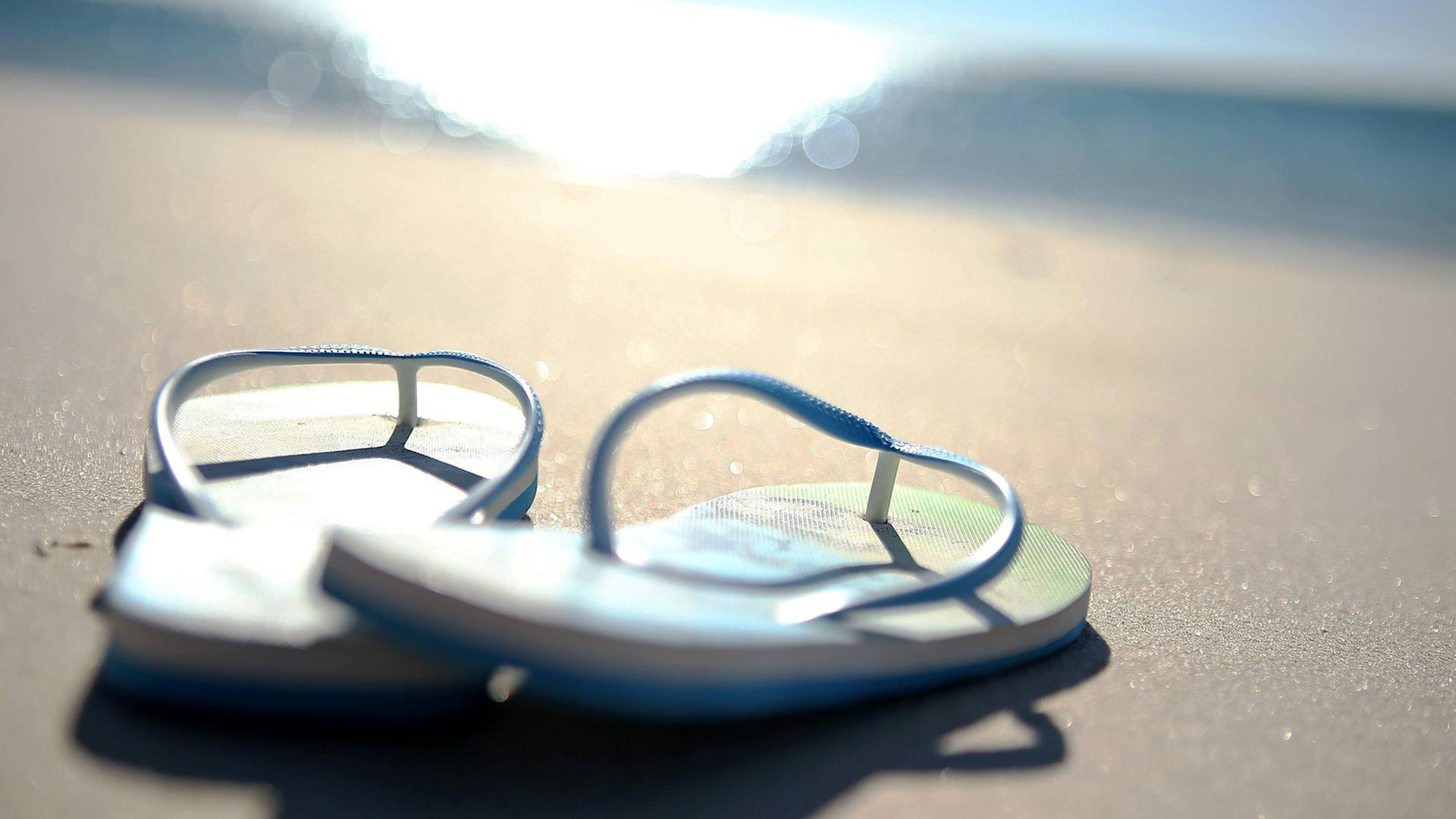 Zwei Badelatschen am Strand Zwei Badelatschen am Strand