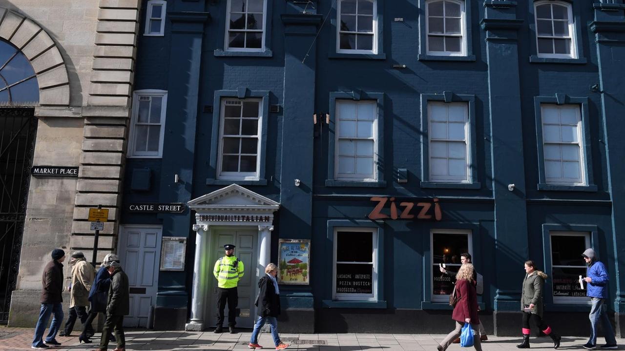A poice officer stands guard outside a branch of the Italian chain restaurant Zizzi close to The Maltings shopping centre in Salisbury, southern England, on March 6, 2018 which was closed in connection to the ongoing major incident sparked after a man and a woman were found critically ill on a bench at the shopping centre on March 4. British police raced Tuesday to identify an unknown substance that left a former Russian double agent fighting for his life, in what a senior lawmaker said bore the hallmarks of a Russian attack. Moscow said it had no information about the "tragic" collapse of the man, identified by the media as Sergei Skripal, in the quiet southern English city of Salisbury on Sunday, but said it would be happy to cooperate if requested by British authorities. Specialist officers from the counter-terrorism squad are helping investigate the incident, which also left a 33-year-old woman -- reported to be Skripal's daughter Yulia -- in a critical condition in what is feared to be a poison plot. / AFP PHOTO / Chris J Ratcliffe A poice officer stands guard outside a branch of the Italian chain restaurant Zizzi close to The Maltings shopping centre in Salisbury, southern England, on March 6, 2018 which was closed in connection to the ongoing major incident sparked after a man and a woman were found critically ill on a bench at the shopping centre on March 4. British police raced Tuesday to identify an unknown substance that left a former Russian double agent fighting for his life, in what a senior lawmaker said bore the hallmarks of a Russian attack. Moscow said it had no information about the "tragic" collapse of the man, identified by the media as Sergei Skripal, in the quiet southern English city of Salisbury on Sunday, but said it would be happy to cooperate if requested by British authorities. Specialist officers from the counter-terrorism squad are helping investigate the incident, which also left a 33-year-old woman -- reported to be Skripal's daughter Yulia -- in a critical condition in what is feared to be a poison plot. / AFP PHOTO / Chris J Ratcliffe