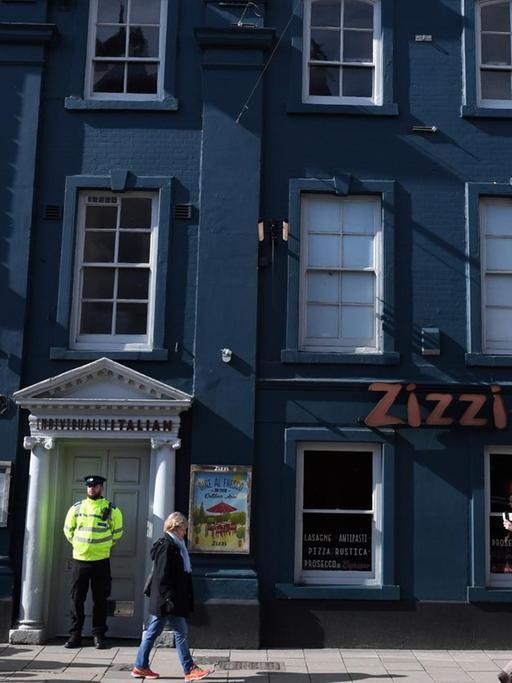A poice officer stands guard outside a branch of the Italian chain restaurant Zizzi close to The Maltings shopping centre in Salisbury, southern England, on March 6, 2018 which was closed in connection to the ongoing major incident sparked after a man and a woman were found critically ill on a bench at the shopping centre on March 4. British police raced Tuesday to identify an unknown substance that left a former Russian double agent fighting for his life, in what a senior lawmaker said bore the hallmarks of a Russian attack. Moscow said it had no information about the "tragic" collapse of the man, identified by the media as Sergei Skripal, in the quiet southern English city of Salisbury on Sunday, but said it would be happy to cooperate if requested by British authorities. Specialist officers from the counter-terrorism squad are helping investigate the incident, which also left a 33-year-old woman -- reported to be Skripal's daughter Yulia -- in a critical condition in what is feared to be a poison plot. / AFP PHOTO / Chris J Ratcliffe