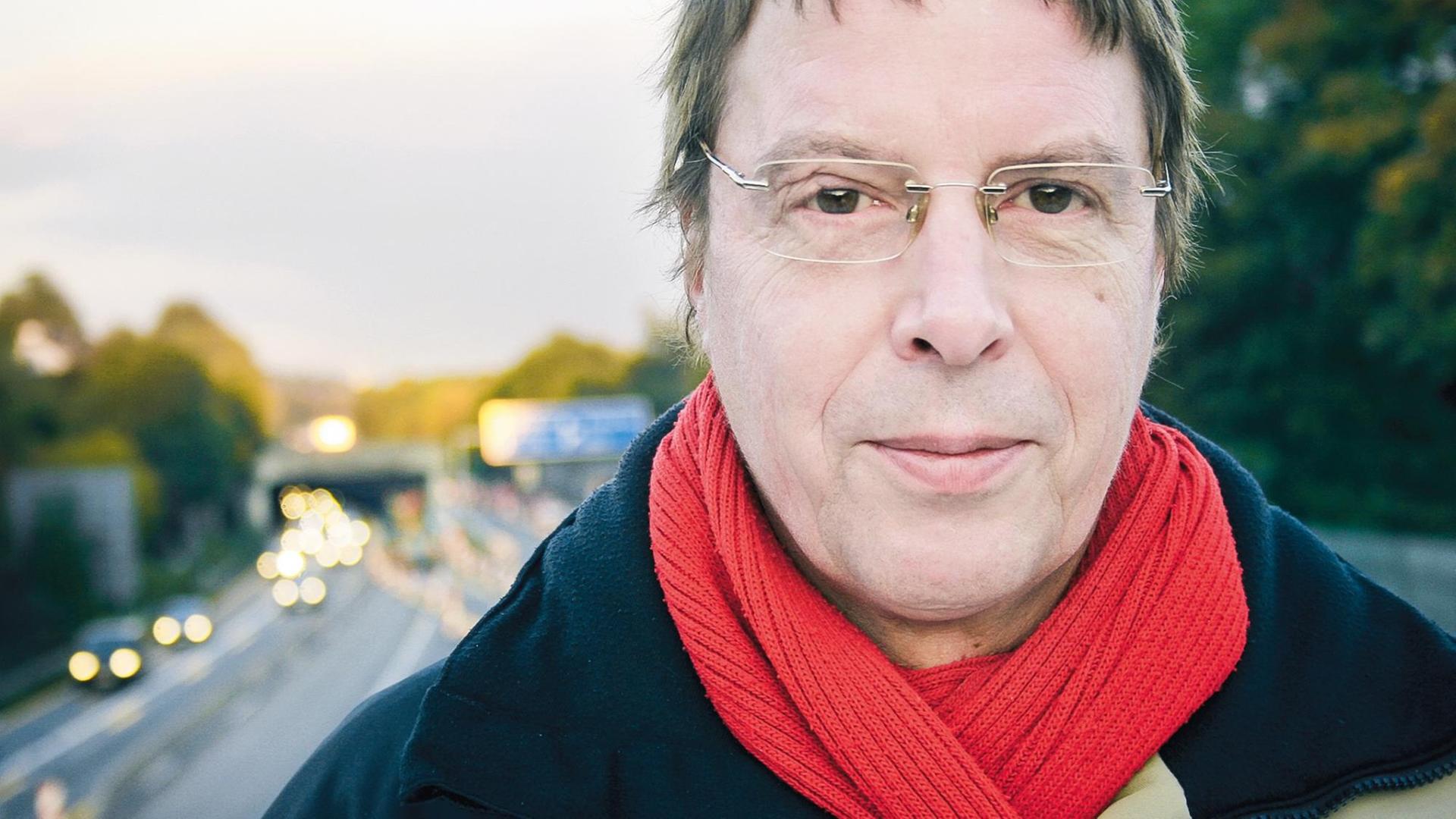 Jochen Dieckmann steht auf einer Autobahnbrücke. Im Hintergrund ist in Unschärfe die Autobahn zu sehen. Jochen Dieckmann steht auf einer Autobahnbrücke. Im Hintergrund ist in Unschärfe die Autobahn zu sehen.