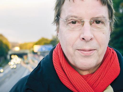 Jochen Dieckmann steht auf einer Autobahnbrücke. Im Hintergrund ist in Unschärfe die Autobahn zu sehen. Jochen Dieckmann steht auf einer Autobahnbrücke. Im Hintergrund ist in Unschärfe die Autobahn zu sehen.