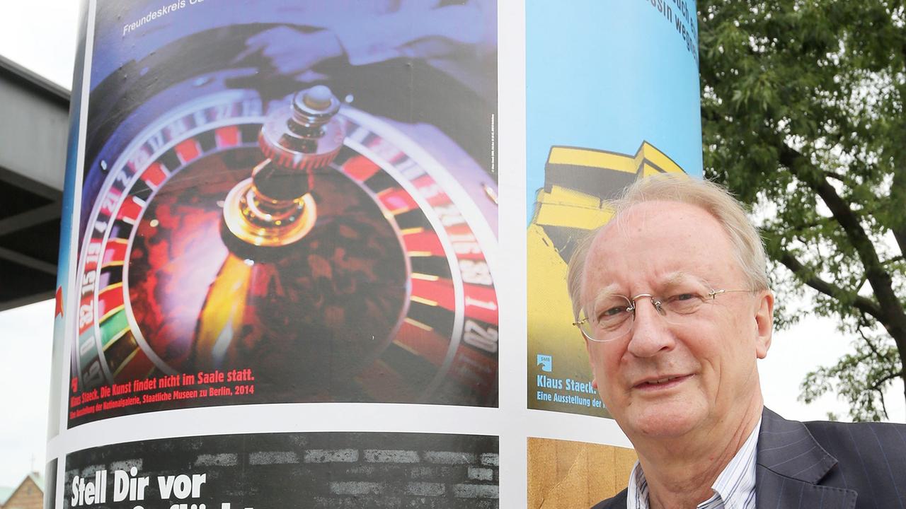 Klaus Staeck steht am 07.08.2014 vor der Neuen Nationalgalerie in Berlin neben einer Litfaßsäule mit seinen Plakaten. Auf einer Pressekonferenz wurde das Projekt von Klaus Staeck "Die Kunst findet nicht im Saale statt" vorgestellt. Es wird für einen Zeitraum von drei Wochen eine Auswahl von 10 Motiven seiner politischen Plakate seit den 1970er-Jahren bis heute auf über 300 Litfaßsäulen in der ganzen Stadt verteilt. Klaus Staeck steht am 07.08.2014 vor der Neuen Nationalgalerie in Berlin neben einer Litfaßsäule mit seinen Plakaten. Auf einer Pressekonferenz wurde das Projekt von Klaus Staeck "Die Kunst findet nicht im Saale statt" vorgestellt. Es wird für einen Zeitraum von drei Wochen eine Auswahl von 10 Motiven seiner politischen Plakate seit den 1970er-Jahren bis heute auf über 300 Litfaßsäulen in der ganzen Stadt verteilt.