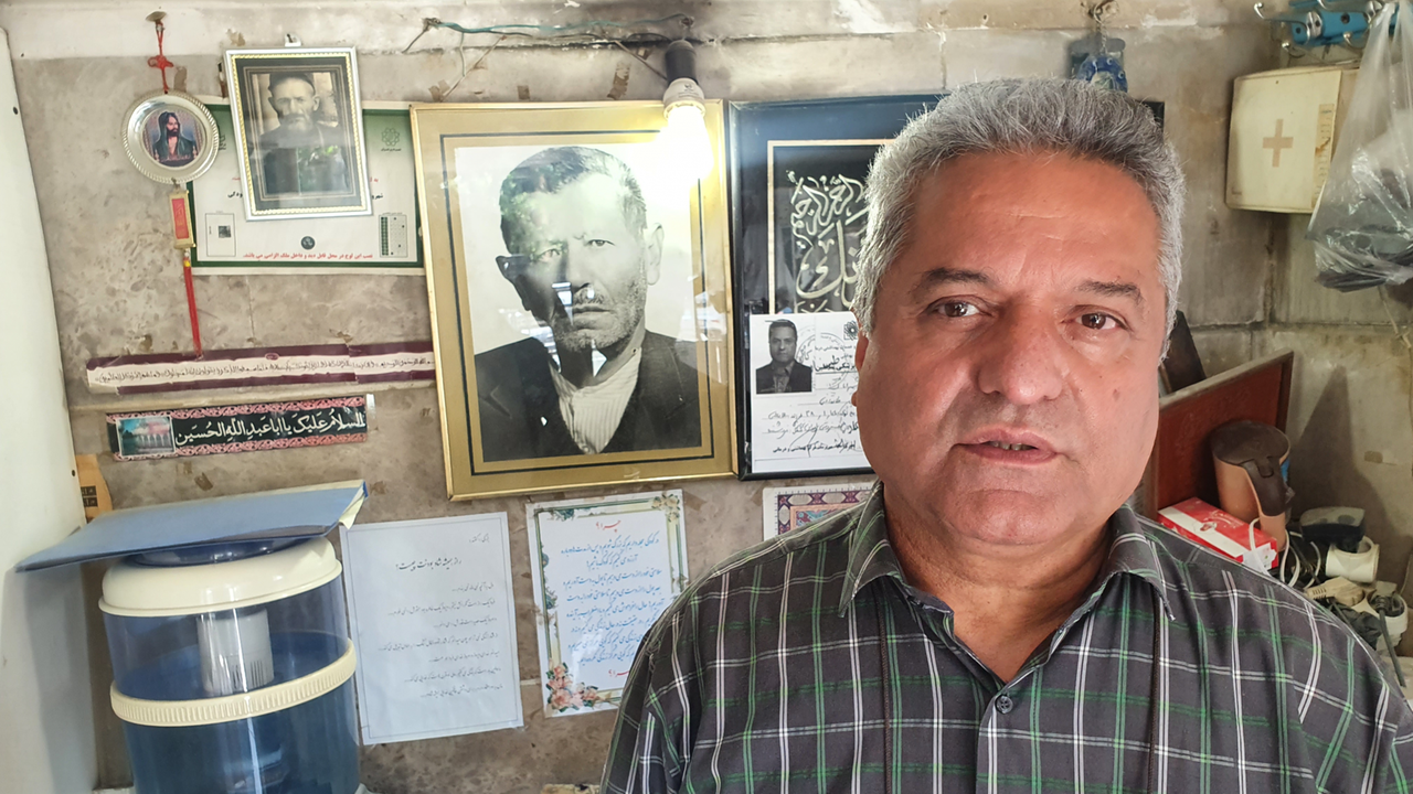 Mohammad Hassan im Büro seiner Teheraner Schreinerei - hinter ihm Fotos seines Vaters und Großvaters, die den Betrieb vor ihm innehatten