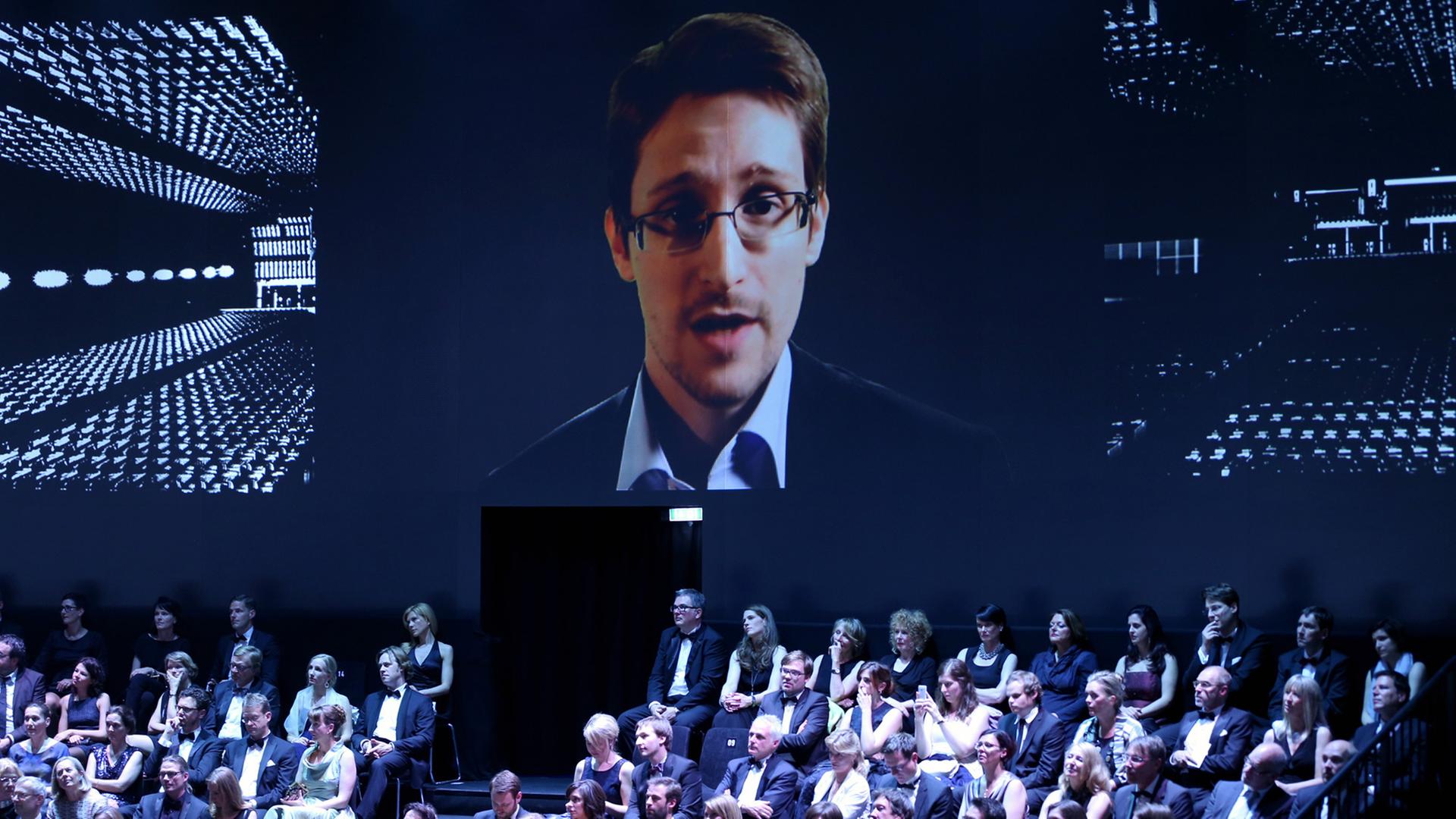 Der ehemalige US-Geheimdienstmitarbeiter Edward Snowden spricht in Hamburg während der Verleihung Henri-Nannen-Preis per Videobotschaft zu den Zuschauern. Der ehemalige US-Geheimdienstmitarbeiter Edward Snowden spricht in Hamburg während der Verleihung Henri-Nannen-Preis per Videobotschaft zu den Zuschauern.