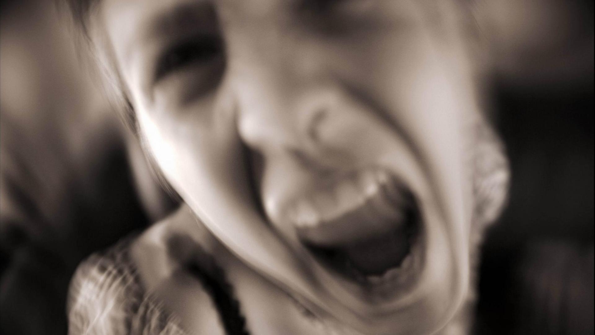 Ein Mädchen schreit aggressiv in die Kamera. Ein Mädchen schreit aggressiv in die Kamera.
