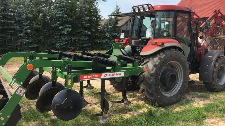 Bauer Krzysztof Zembrowski fährt mit seinem roten Traktor vor. Bauer Krzysztof Zembrowski fährt mit seinem roten Traktor vor.