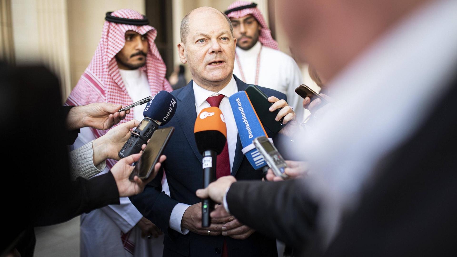 Olaf Scholz spricht in Mikrofone. Olaf Scholz spricht in Mikrofone.