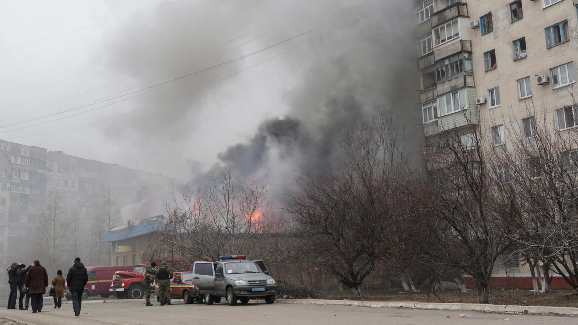 Flammen und Rauch kommen aus einem Haus in Mariupol. Ein ganzes Wohnviertel wurde beschossen. Flammen und Rauch kommen aus einem Haus in Mariupol. Ein ganzes Wohnviertel wurde beschossen.
