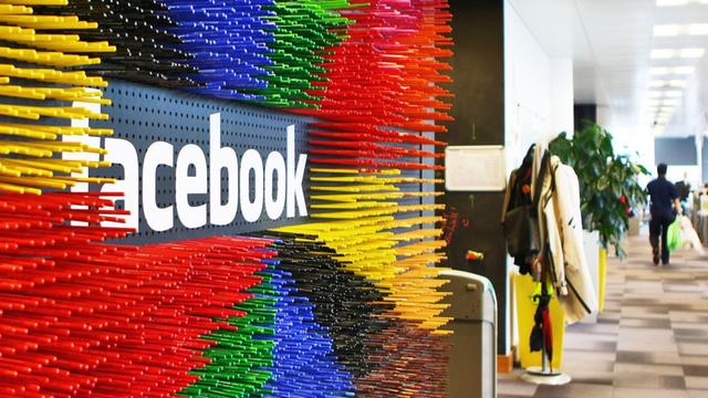 Zahlreiche bunte Filzstifte in der Facebook-Europazentrale in Dublin neben dem Firmenlogo.