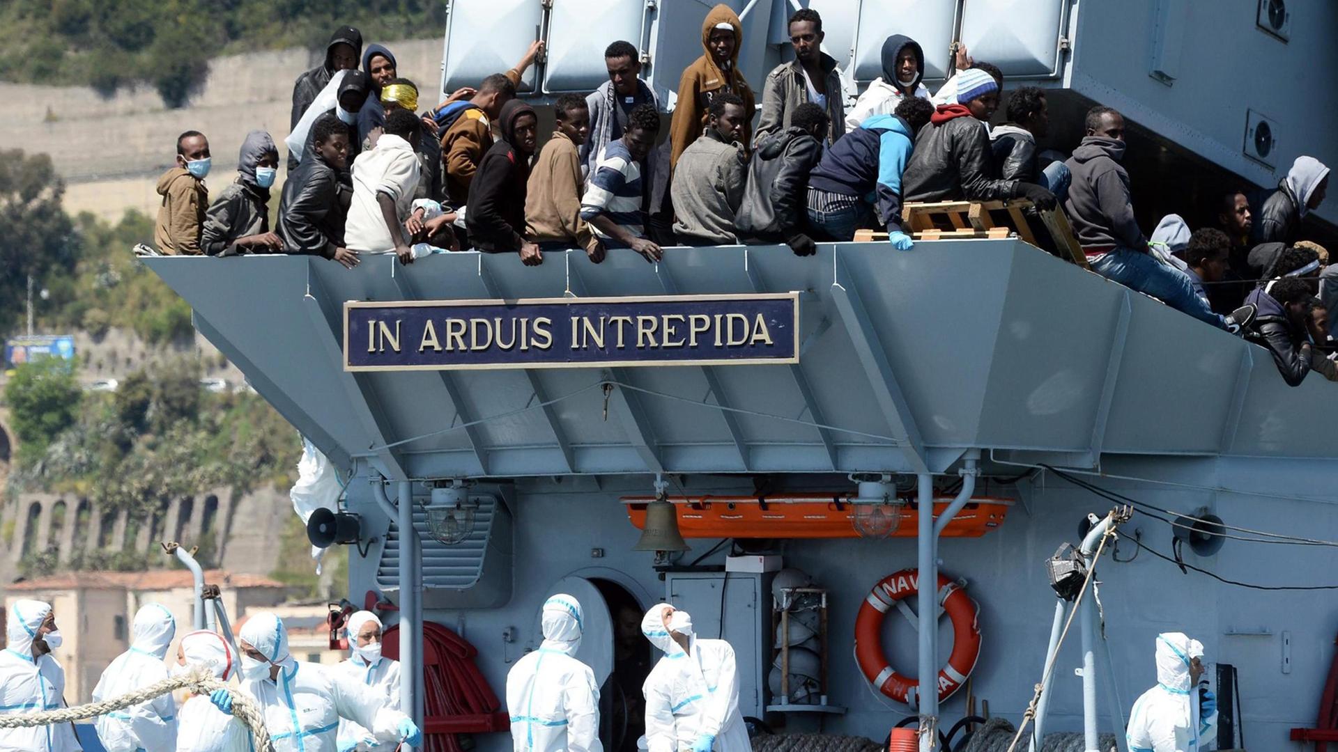 Aus dem Mittelmeer gerettete Flüchtlinge kommen an Bord eines italienischen Marineschiffes in Salerno an. Aus dem Mittelmeer gerettete Flüchtlinge kommen an Bord eines italienischen Marineschiffes in Salerno an.