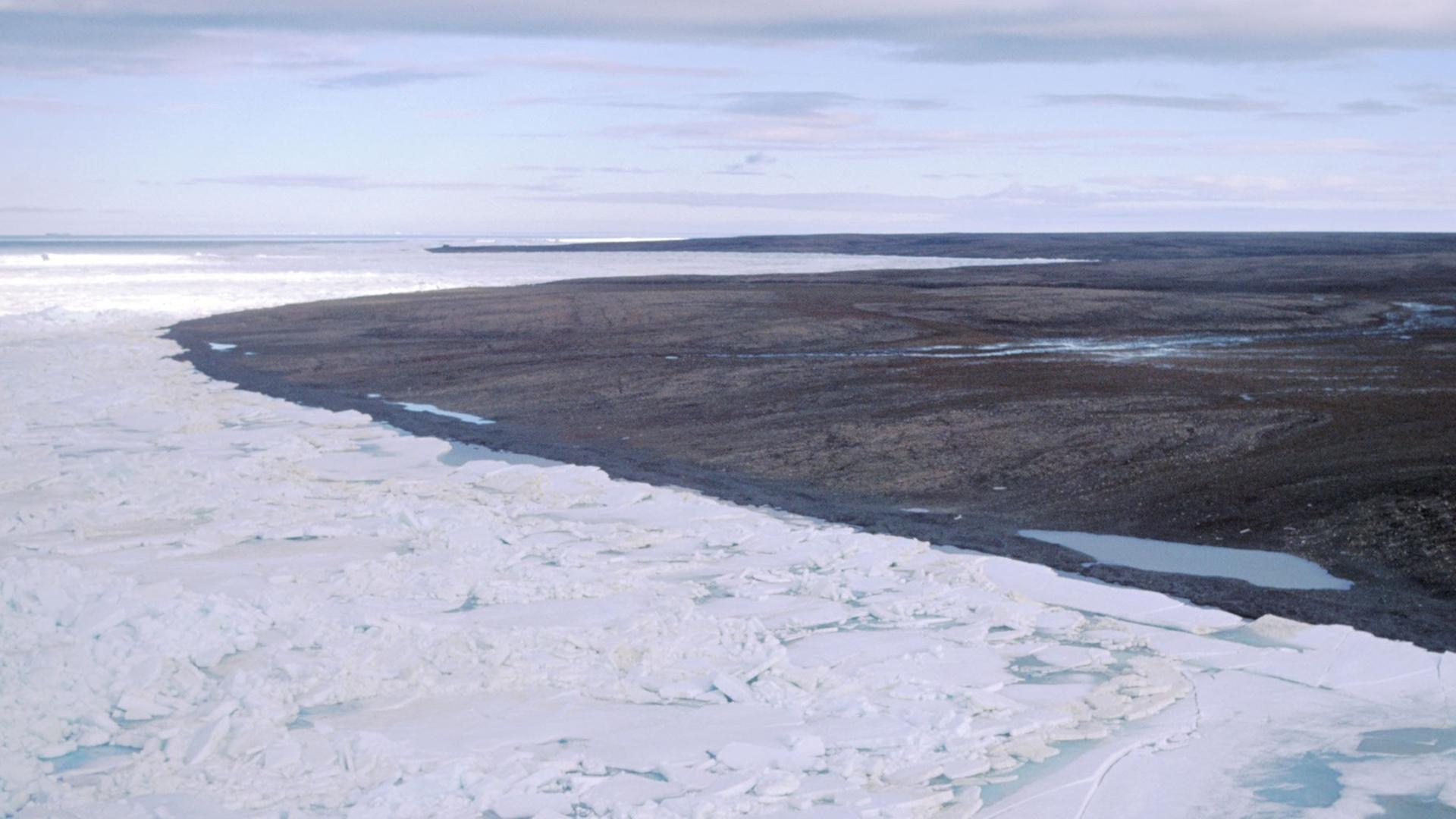 Blick über eine durch Dauerfrost (Permafrost) gezeichnete Landschaft auf der zur Russland gehörenden Bolschewik Insel, während im Vordergrund noch Packeis herrscht ist im Hintergrund die Landschaft schon aufgetaut und schlammig. Blick über eine durch Dauerfrost (Permafrost) gezeichnete Landschaft auf der zur Russland gehörenden Bolschewik Insel, während im Vordergrund noch Packeis herrscht ist im Hintergrund die Landschaft schon aufgetaut und schlammig.