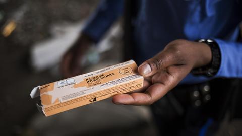 Ein Polizist aus Philadelphia hält eine Packung mit einem Gegenmittel bei Opioid-Vergiftungen in der Hand. Die werden im ganzen Land verteilt.