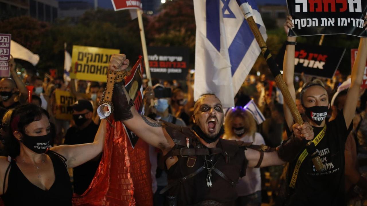 Demonstrierende mit israelischen Flaggen, zum Teil mit Mundschutz, äußern ihren Unmut Demonstrierende mit israelischen Flaggen, zum Teil mit Mundschutz, äußern ihren Unmut