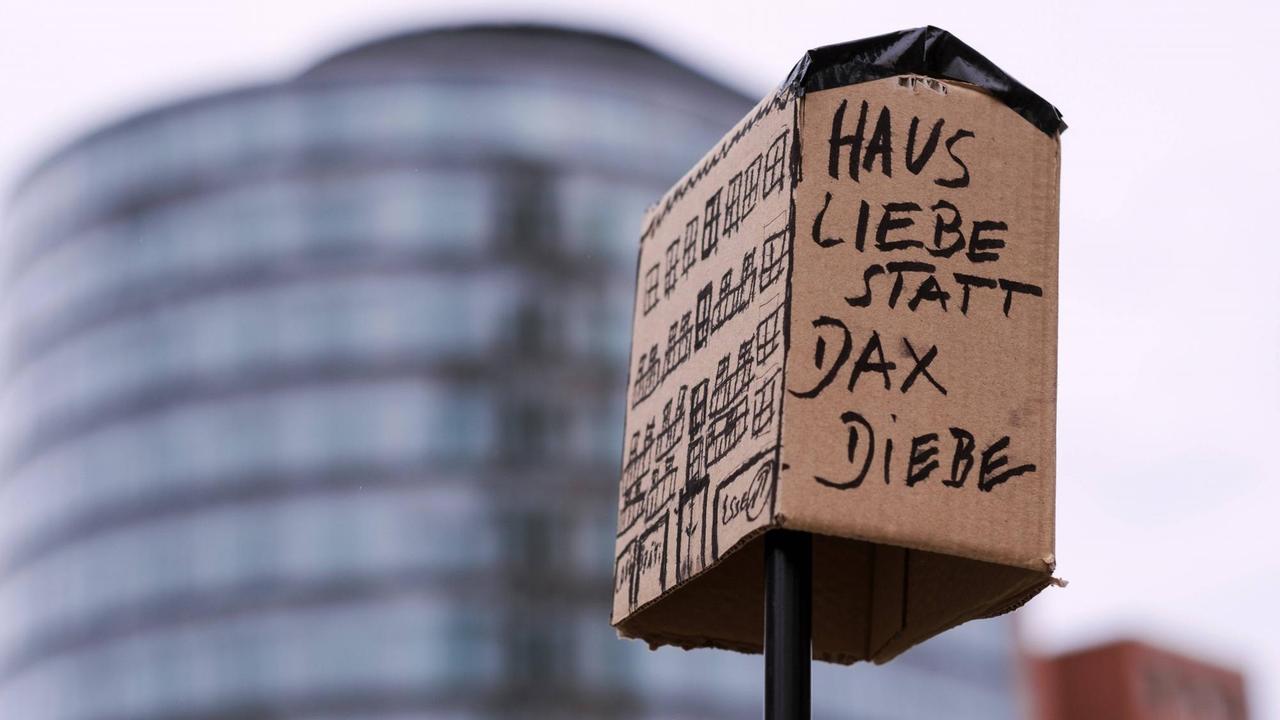 "Haus Liebe statt Dax Diebe" seht auf einem als Protestplakat funktionierenden Haus aus Pappe.