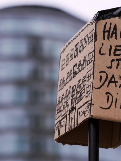 "Haus Liebe statt Dax Diebe" seht auf einem als Protestplakat funktionierenden Haus aus Pappe.