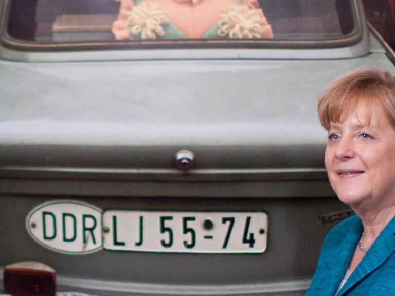 Bundeskanzlerin Angela Merkel in Berlin bei der Eröffnung der Fotoausstellung "Über Leben" im Deutschen Historischen Museum vor einem Bild von Thomas Hoepker mit dem Motiv eines Trabis.