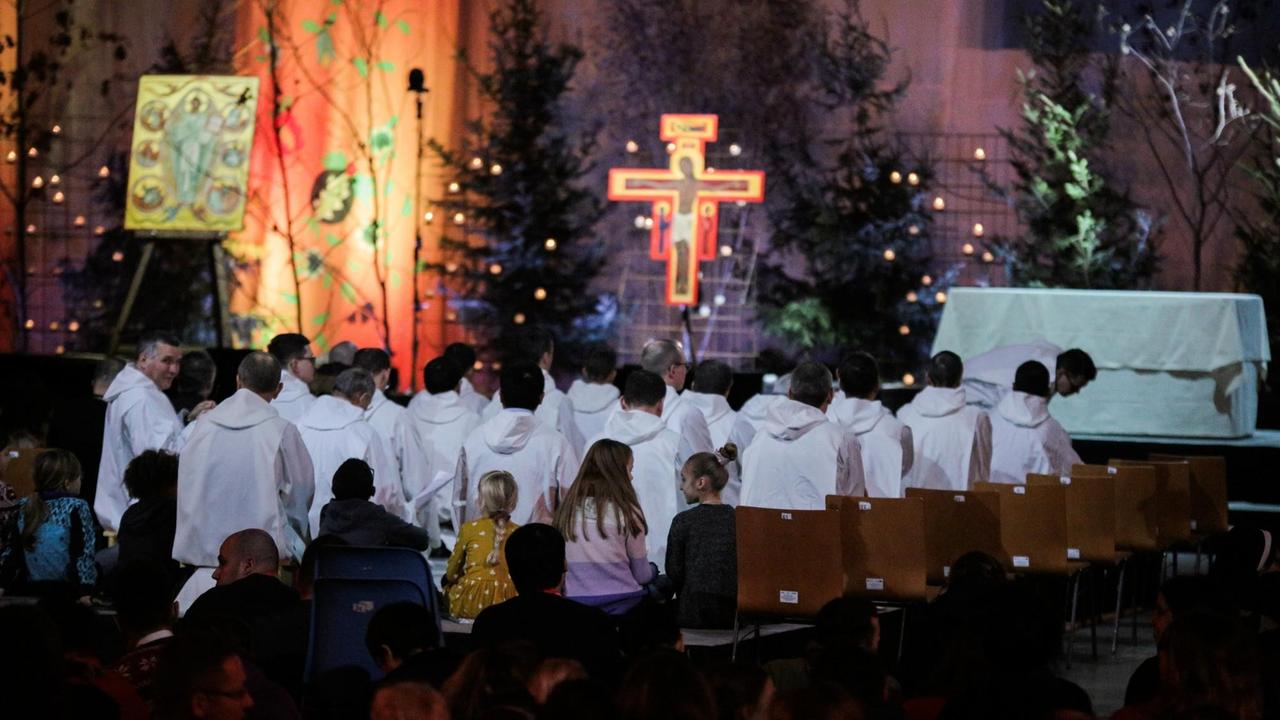 Teilnehmer stehend und sitzend vor einem Kreuz beim 42. Europäischen Jugendtreffen der Taizé-Gemeinschaft in der festlich illuminierten Jahrhunderthalle in Breslau. Teilnehmer stehend und sitzend vor einem Kreuz beim 42. Europäischen Jugendtreffen der Taizé-Gemeinschaft in der festlich illuminierten Jahrhunderthalle in Breslau.