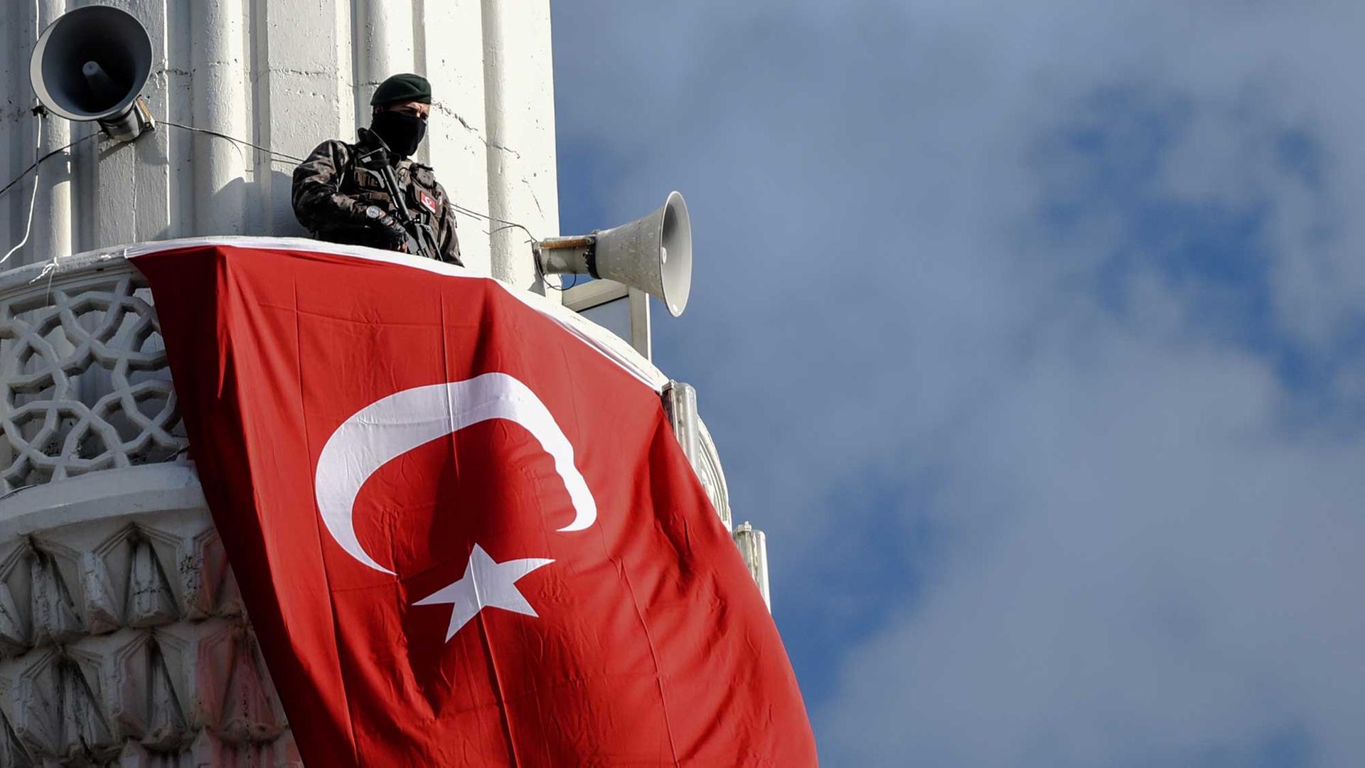 Ein türkischer Polizist bewacht am 18.12.2016 auf dem Minarett einer Moschee die Beerdigung des türkischen Soldaten Fehmi Barcin, der einen Tag zuvor bei einem Angriff in Kayseri getötet worden war. Ein türkischer Polizist bewacht am 18.12.2016 auf dem Minarett einer Moschee die Beerdigung des türkischen Soldaten Fehmi Barcin, der einen Tag zuvor bei einem Angriff in Kayseri getötet worden war.