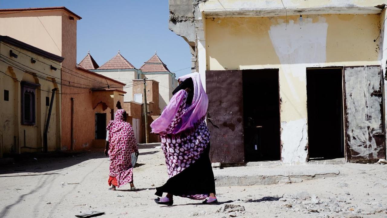 Zwei verschleierte Frauen auf einer sandigen Straße in Mauretaniens Hauptstadt Nouakchott