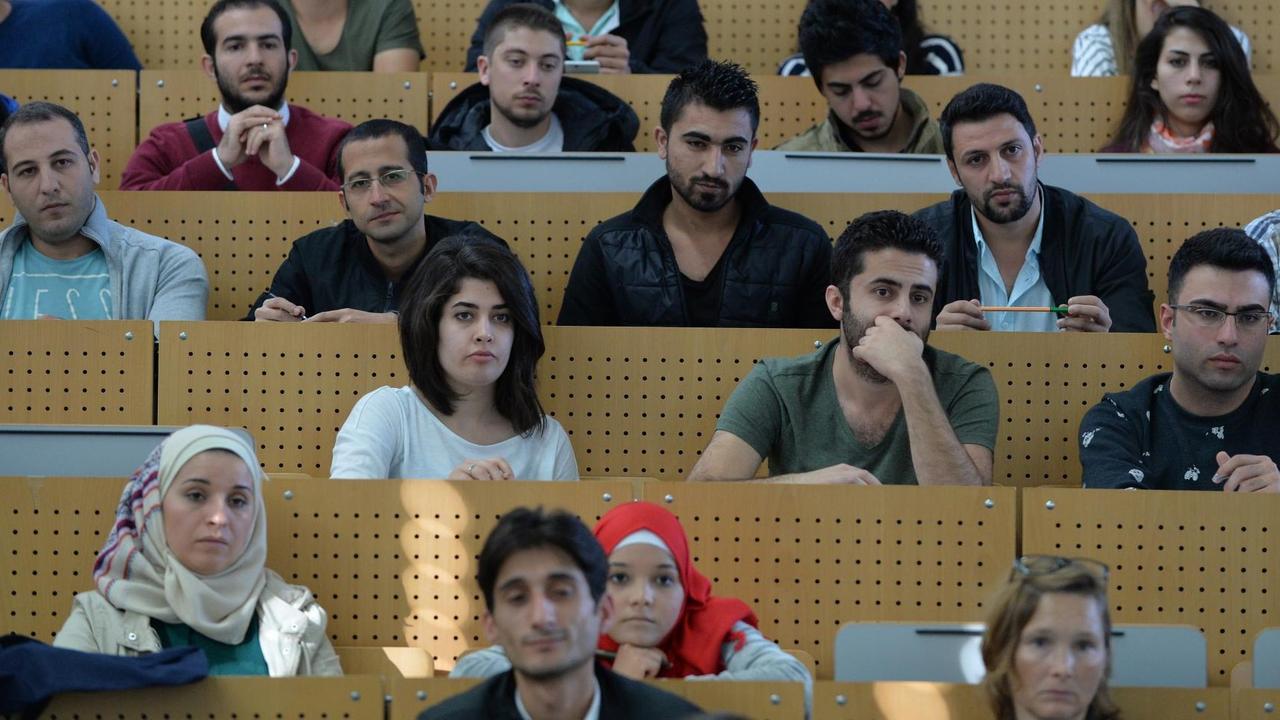 Studentinnen und Studenten sitzen am 04.10.2016 in Bremen bei einer Einführungsveranstaltung der Universität in einem Hörsaal. Sie sind Flüchtlinge aus verschiedenen Ländern, vor allem aber aus Syrien. Alle haben einen akademischen Hintergrund und zuvor das Bewerbungsverfahren durchlaufen. Foto: Carmen Jaspersen/dpa | Studentinnen und Studenten sitzen am 04.10.2016 in Bremen bei einer Einführungsveranstaltung der Universität in einem Hörsaal. Sie sind Flüchtlinge aus verschiedenen Ländern, vor allem aber aus Syrien. Alle haben einen akademischen Hintergrund und zuvor das Bewerbungsverfahren durchlaufen. Foto: Carmen Jaspersen/dpa |