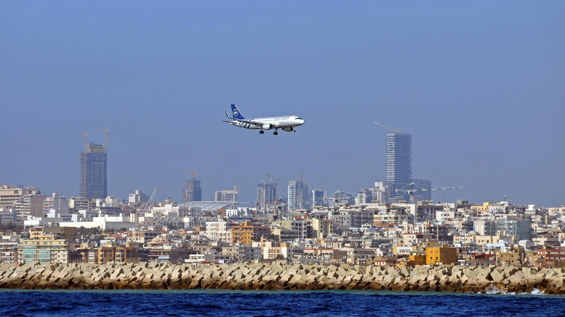 Man sieht ein Flugzeug und dahinter die Hochhäuser der Stadt Beirut. Man sieht ein Flugzeug und dahinter die Hochhäuser der Stadt Beirut.