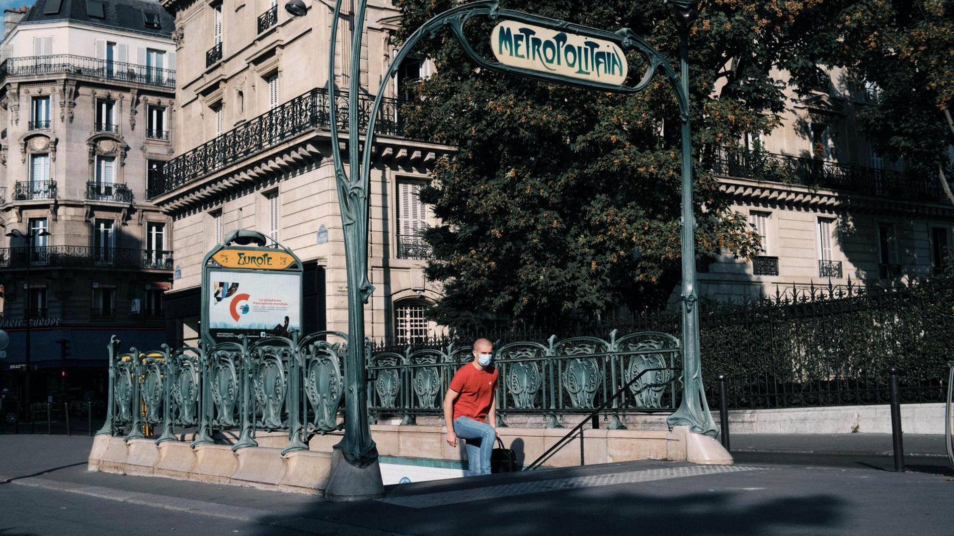 Ein Mann mit Mund-Nasen-Schutz-Maske kommt aus einer Metro-Station in Paris.