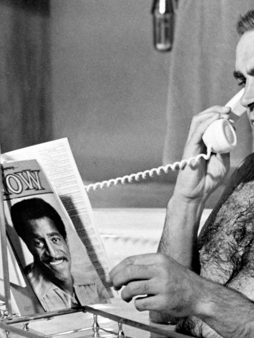 Sean Connery als James Bond in der Badewanne am Telefonieren und Zeitschrift durchblättern, Schwarz-Weiß-Foto