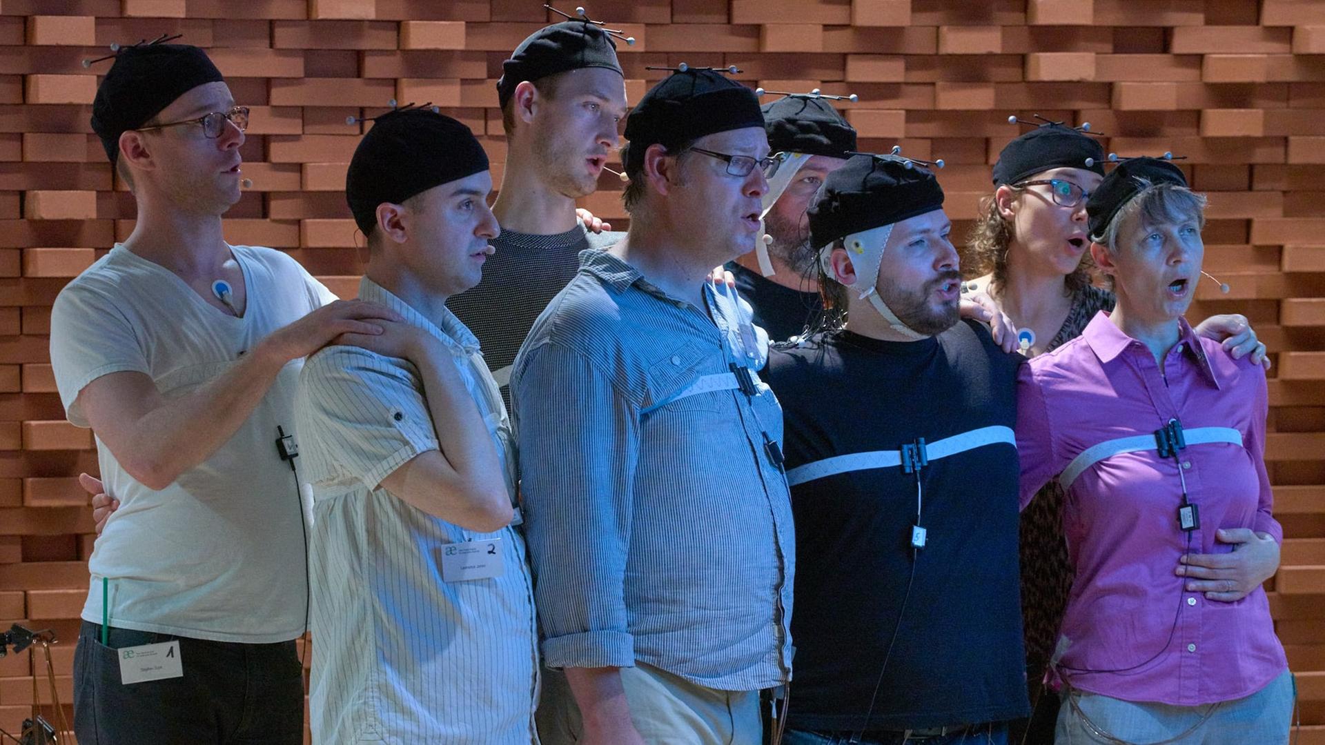 Das Vokalensemble CutCircle singt mit verkabelten Kopfbedeckungen bei Messungen im ArtLab des Max-Planck-Instituts für empirische Ästhetik Das Vokalensemble CutCircle singt mit verkabelten Kopfbedeckungen bei Messungen im ArtLab des Max-Planck-Instituts für empirische Ästhetik