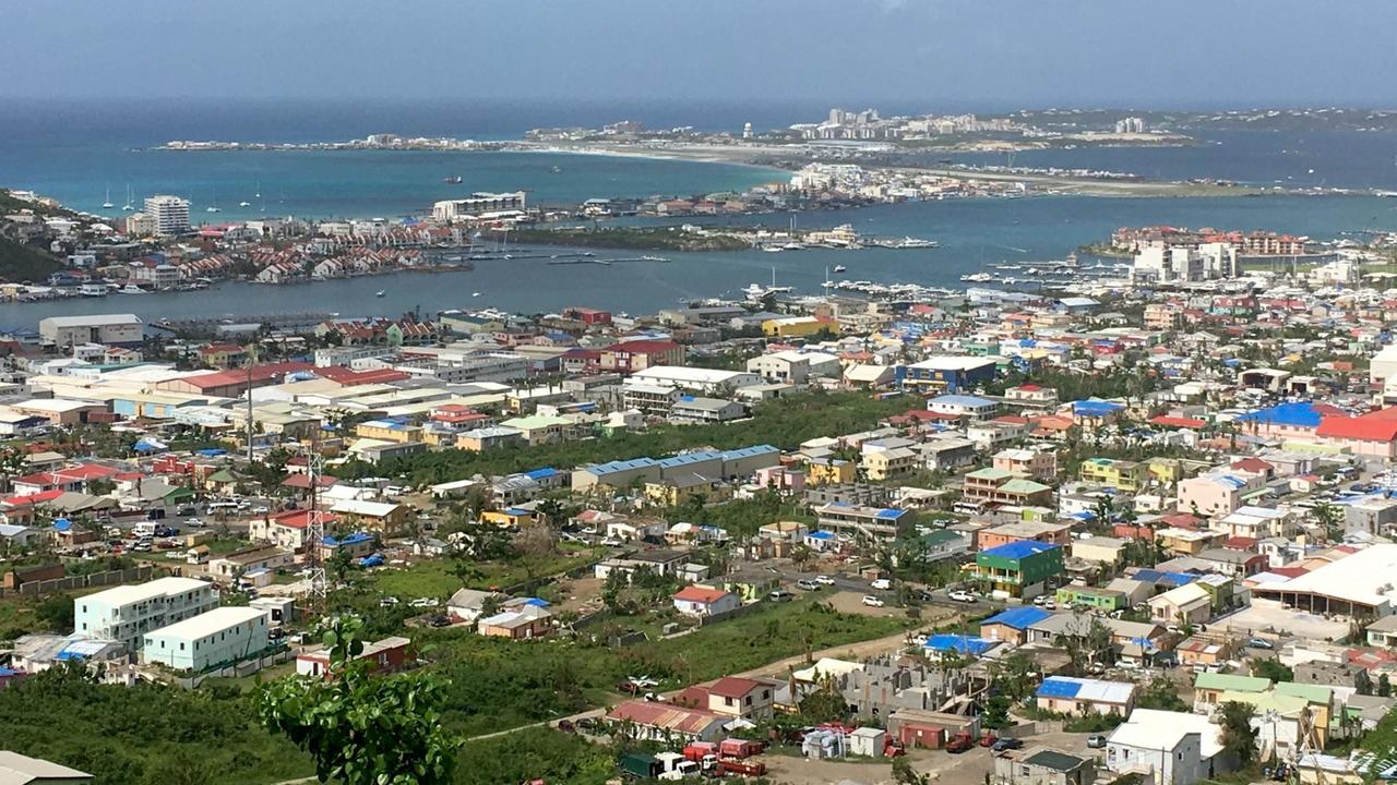 Blick auf die Stadt am Strand, Häuser mit blauen Planen Blick auf die Stadt am Strand, Häuser mit blauen Planen