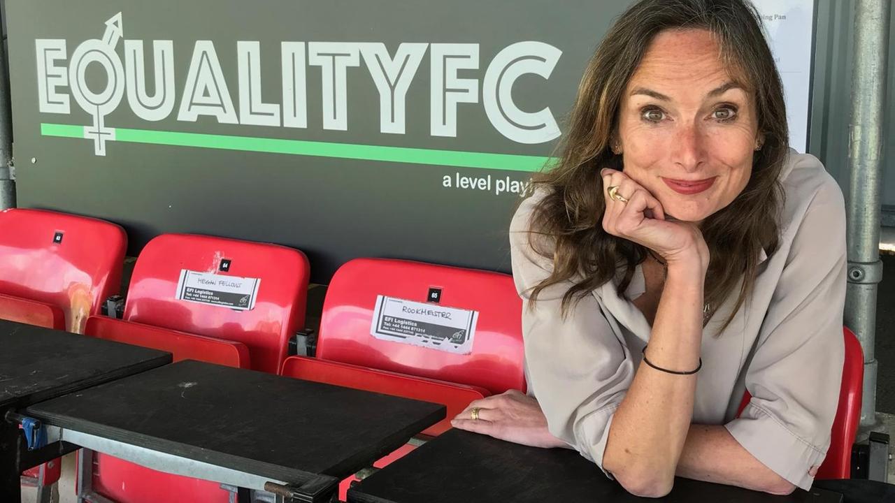 Karen Dobres sitzt im Stadion vor einem Plakat mit der Aufschrift "Equality FC". Karen Dobres sitzt im Stadion vor einem Plakat mit der Aufschrift "Equality FC".