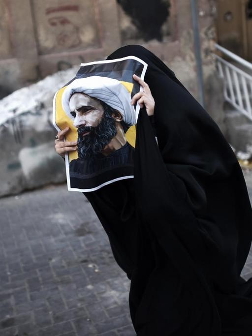 Eine Frau aus Bahrain hält ein Poster mit dem Foto des Schiiten Nimr al-Nimr während einer Protestkundgebung gegen seine Hinrichtung durch die saudi-arabische Regierung.